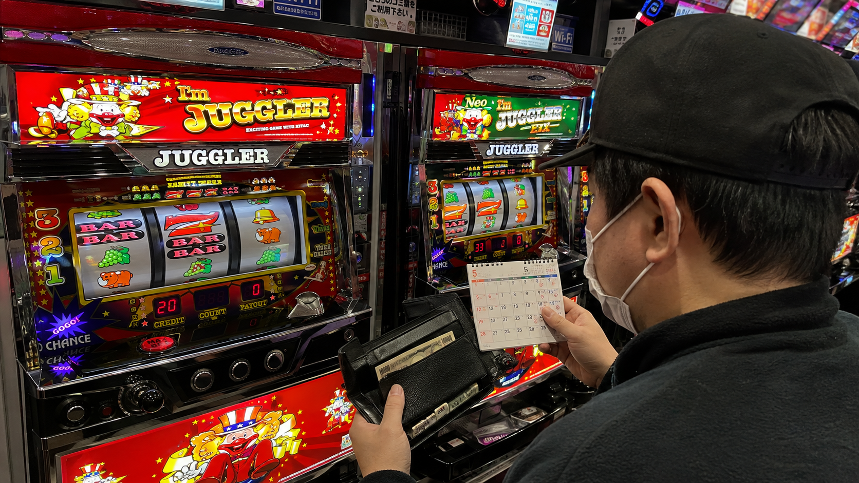 アイムジャグラー系の実機を前に財布と週2日の遊技予定を確認する客