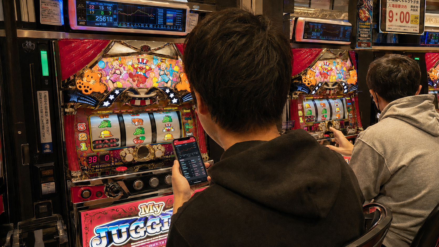 収支を考える経験者と操作を確かめる初心者がいるジャグラーの店内