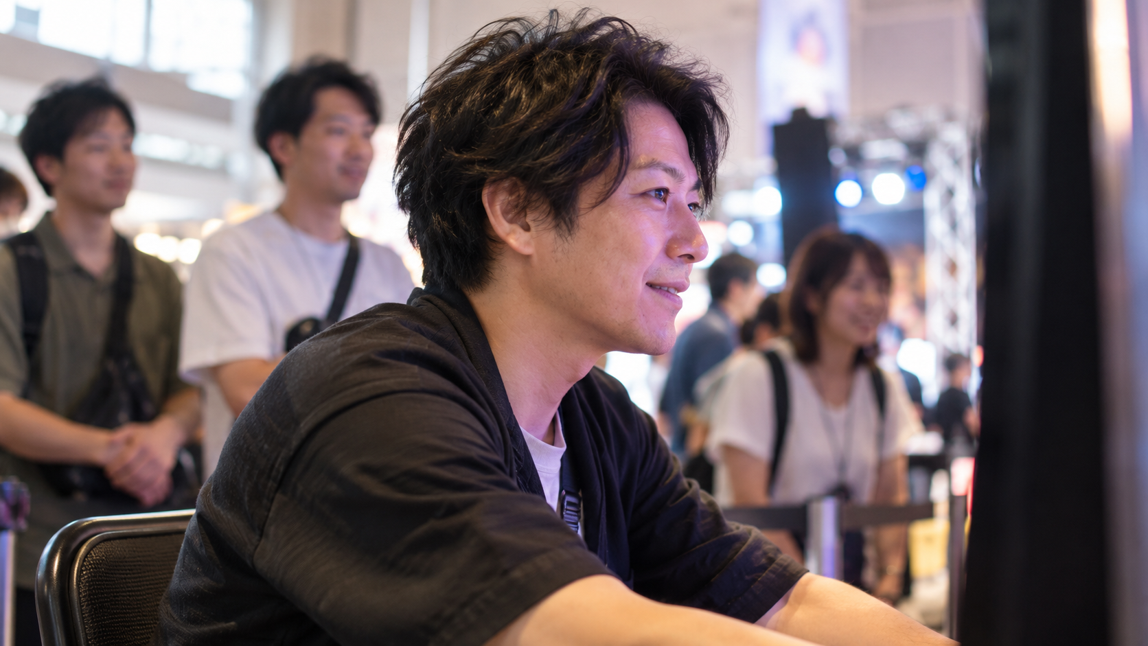 試遊機の画面に集中し、期待の表情を見せる成人参加者のイメージ