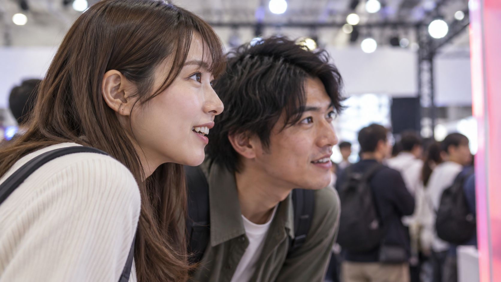 フェスの展示スペースで展示物に関心を向ける成人来場者のイメージ